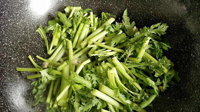 老干妈辣炒茼蒿,香味出来以后先把茼蒿梗放进去