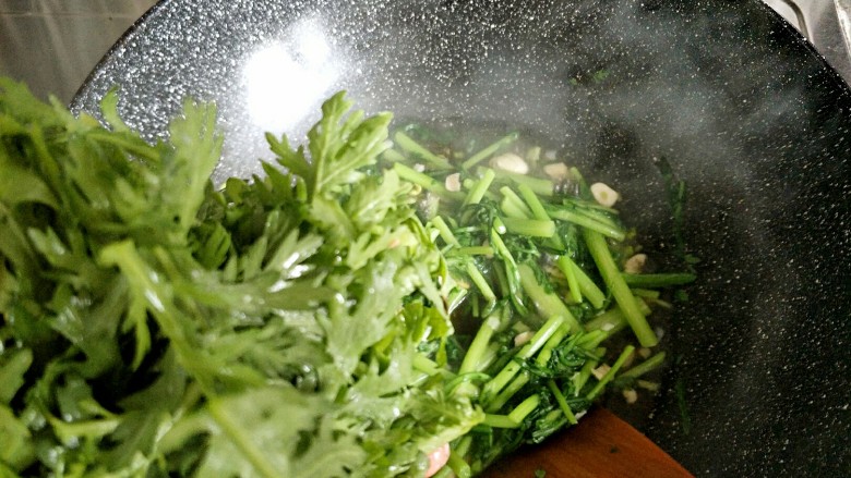 老干妈辣炒茼蒿,炒到梗稍微变色,再把茼蒿叶子放进去