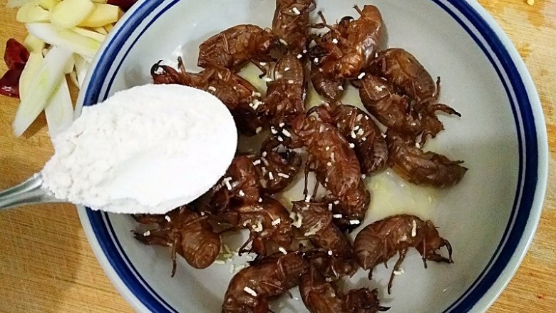 香酥蝉蜕 ,在洗净的蝉蜕中加入1勺<a style='color:red;display:inline-block;' href='/shicai/ 718'>料酒</a>（10g左右），少许<a style='color:red;display:inline-block;' href='/shicai/ 756'>鸡精</a>，1大勺裹炸粉（30g左右）。