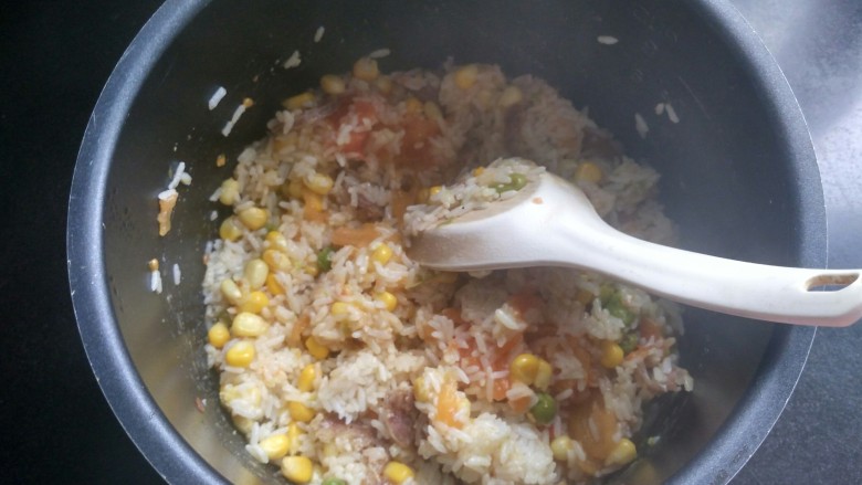 电饭煲 番茄腊肠焖饭,用饭勺搅拌均匀。