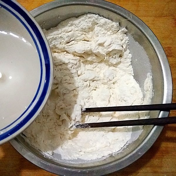 三鲜蒸饺,在<a style='color:red;display:inline-block;' href='/shicai/ 519'>面粉</a>中少量多次加入冷水,用筷子搅拌成雪花状。
