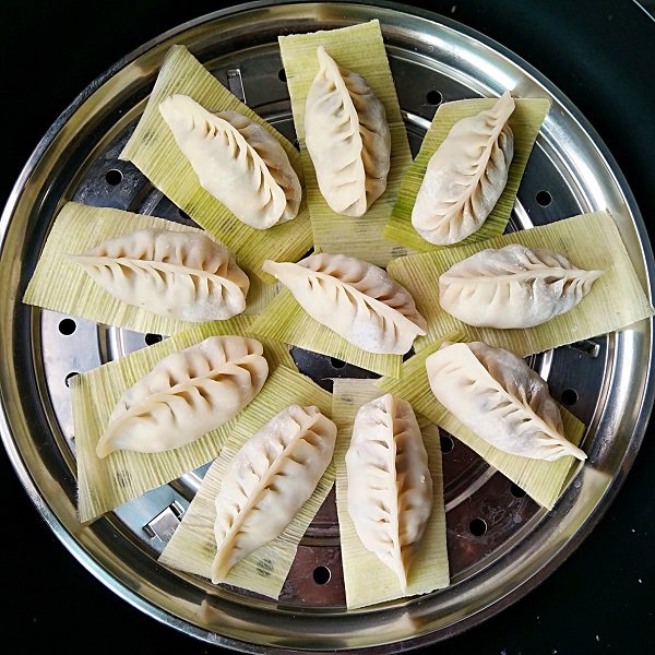 三鲜蒸饺,将玉米皮剪成合适的大小,垫在饺子下面放在篦子上,上锅隔水蒸15分钟。一开锅的时候就会闻到玉米呢香味儿呢!