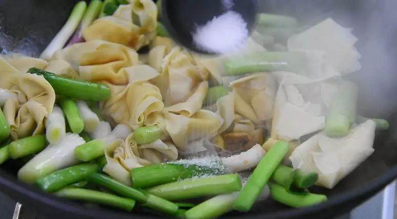豆腐皮的美味做法,简单易上手,营养爆表!,根部炒至微微变软后,倒入百叶,淋上生抽、糖翻炒