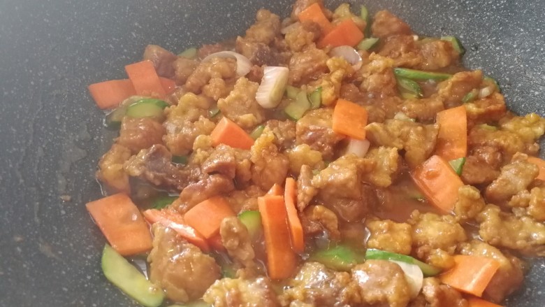 东北菜_糖醋溜肉段,加调好的淀粉水和肉段翻炒,淀粉水先加一半,看看汤汁少就再加点,一下加多了就太粘稠了不好看也不好吃。