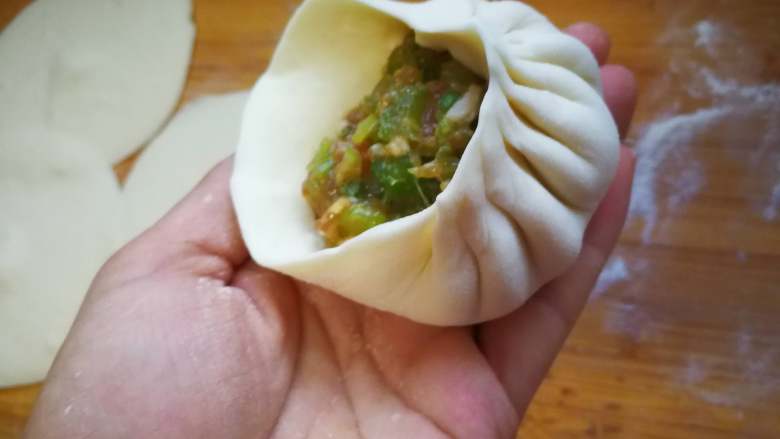 指尖舞动-提褶包,左手托着包子胚,用右手的拇指、食指、中指均匀的捏出褶子。