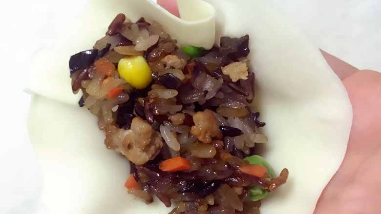超级好吃的饺子皮烧麦,饺子皮放在手心,中间放入炒好的糯米饭。