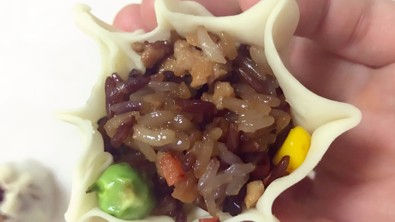 超级好吃的饺子皮烧麦,捏出花边,用虎口,把皮全部包上,在花边下方,用虎口收紧捏一下,依次做好剩余烧麦。