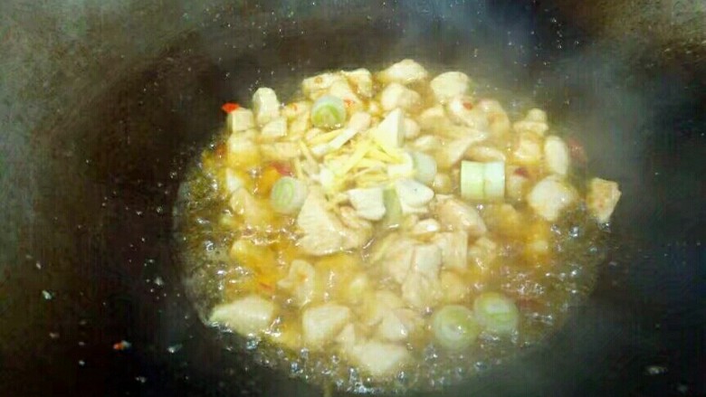 杏鲍菇炒鸡丁,放入葱姜蒜,翻炒均匀。