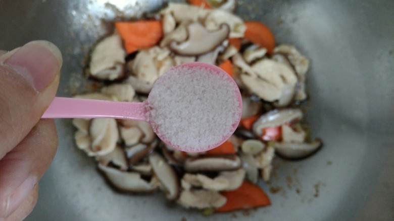 香菇滑鸡片,加入适量食盐,翻炒均匀。