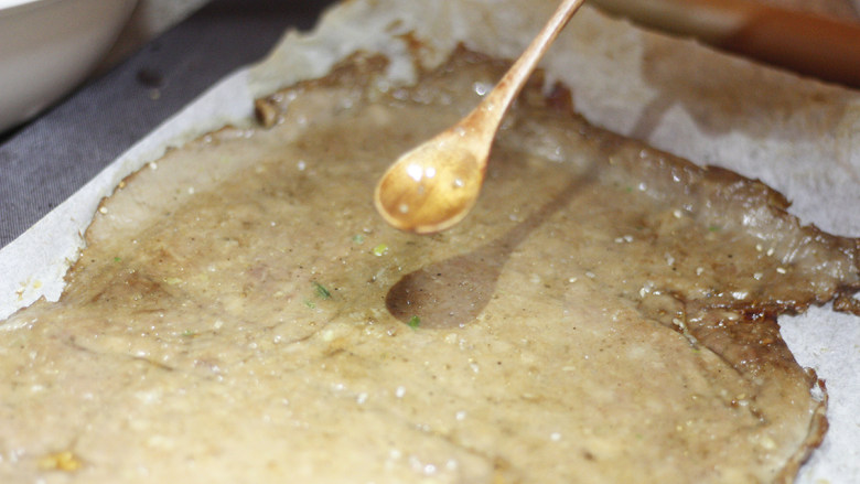 甜脆香酥的猪肉脯,完成第一次烤制的肉脯片从烤箱取出,将其翻面放置,刷上一层蜂蜜