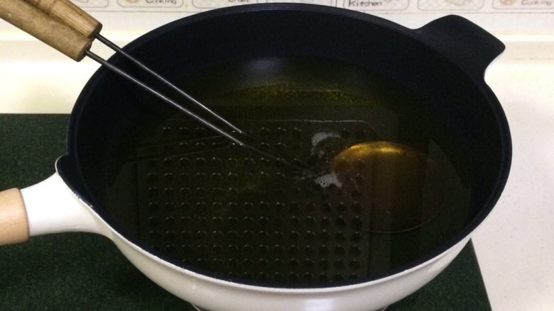 福建小吃—油饼,开大火,往锅内倒入食用油,把油饼勺一起放入锅内加热。