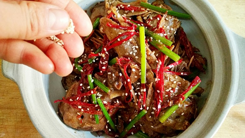干锅鸭头,出锅后撒上白芝麻即可,为了吃完方便涮锅,我直接用砂锅盛了。