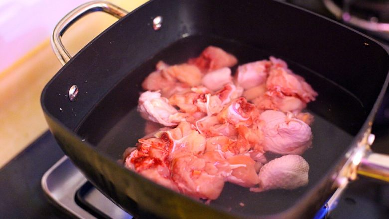 家庭版三杯鸡,锅内放水没过鸡肉待浮沫飘出关火,用水冲净鸡块沥干水份备用。