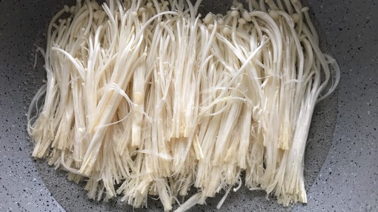 金针菇黄瓜卷,锅中放入水,烧开,放入金针菇将金针菇烧熟