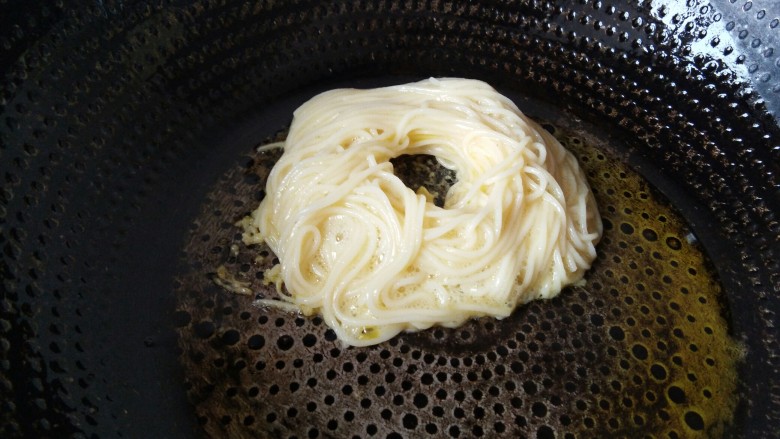 金丝雀巢鸡蛋面,油热下去面条,中间用筷子挖出来个洞,留着放蛋黄。