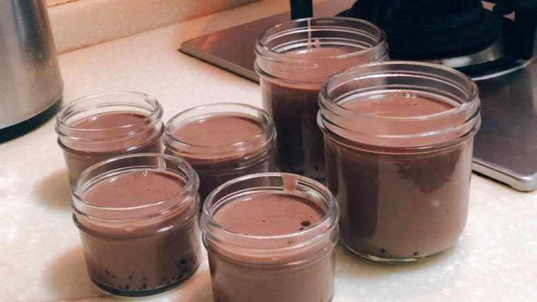 低脂低卡可可绵密奶冻 改良版意式Panna Cotta,奶冻用勺子勺入,装至8分满即可。这个时候奶液是纯液体状的,不用担心。盖上盖子,放在冰箱冷藏4小时以上,那个时候就是厚重浓郁的奶冻了~