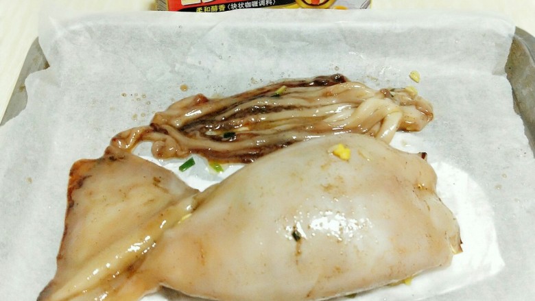 #鱿鱼与炒饭的新吃法#~咖喱鱿鱼包饭,将鱿鱼包饭放入垫有油纸的烤盘中。