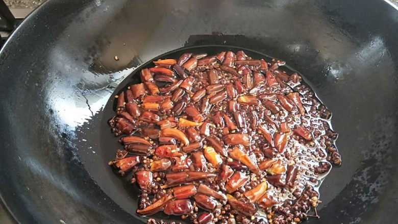年夜菜麻辣水煮肉片,放入大量的干辣椒,炒香