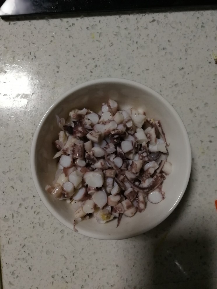 海鲜炒饭,将鱿鱼切成小块,放入碗中,