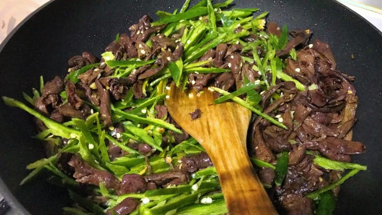 爆炒野生粘蘑,颠匀,让调味料均匀粘附在蘑菇和辣椒上。
