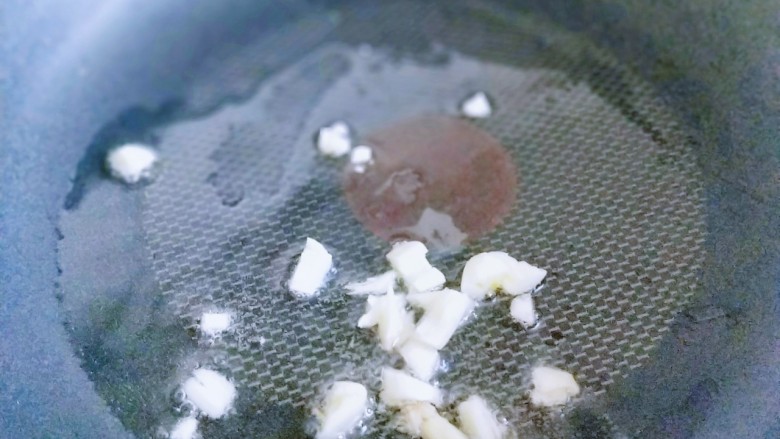 松茸火腿炒青椒,起油锅,加入蒜炒香。