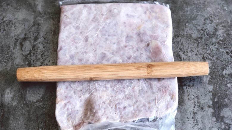 芋泥麻薯肉松盒子蛋糕,放在保鲜袋子里,用擀面杖擀压成香芋泥