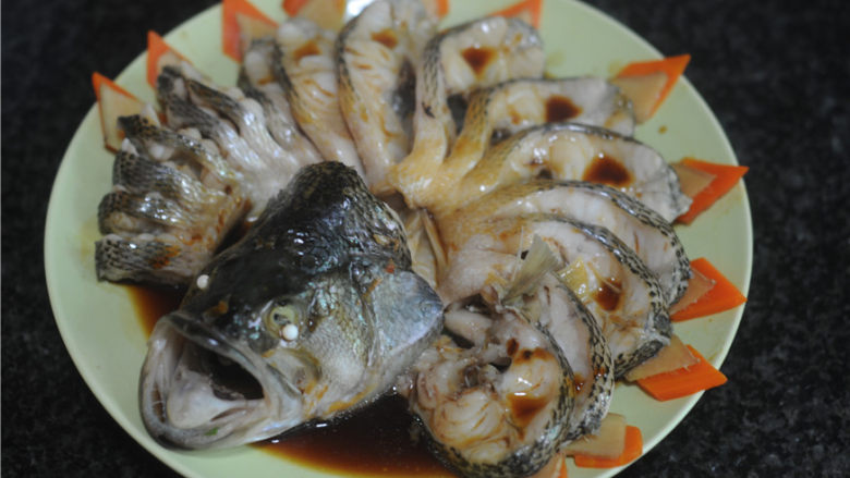 春节宴客菜—清蒸鲈鱼,油锅炒香姜丝,淋入生抽烧开,淋在鲈鱼上面,撒上葱花即可