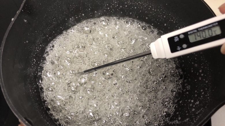 熬糖版花生牛轧糖,糖浆熬至138度以上,一般我煮到142度,这个过程很关键,一定要有耐心,熬糖温度一定要到位,温度计测量温度的时候温度计尽量不要接触锅底和锅边,会出现温度虚高现象,糖浆熬到142度就可以关火了。
如果没有温度计的也可以学着看状态,糖浆刚沸腾后锅里一直冒大泡泡,熬到一定温度的时候会变成许多密集的小泡泡,这个时候糖浆的温度就差不多了,熬糖浆的时间跟你的火力大小、锅的厚度、受热度都有关系,另外还有一个简单测试温度的办法,准备一碗冷水,糖浆状态差不多到了以后,用一根筷子蘸点糖浆迅速滴到冷水里,如果糖浆变硬,变脆,可以轻松折断就表示糖浆的温度可以了。
新手做熬糖版建议备个温度计。