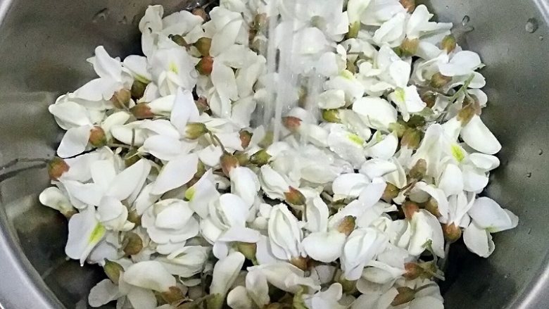 手撕槐花饼,去梗留花,过水洗净。