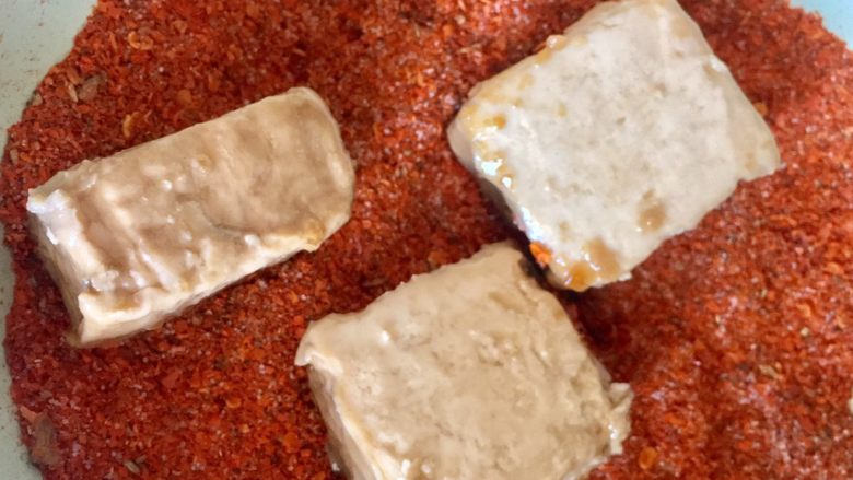 自制油豆腐乳,豆腐侵泡过后,放入辣椒碗。