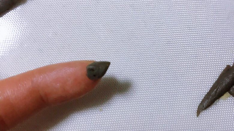 肥美小蜜蜂椰蓉包,取剩余的黑色面团,制作蜜蜂的小屁股和触角。
取0.5克黑色面团揉成三角形,成为蜜蜂的小屁股