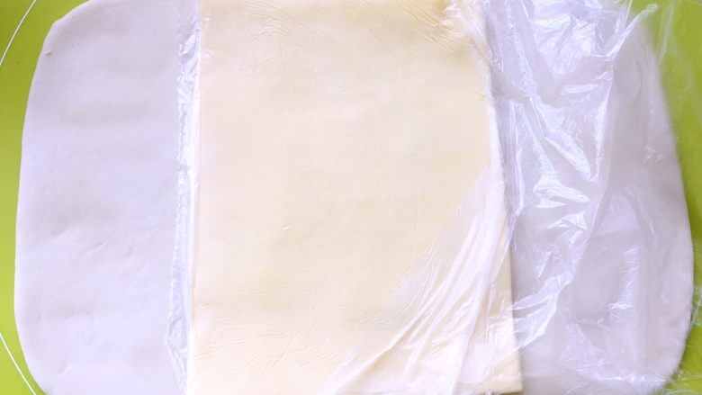 白富美跟粉小妹,取出冷冻的黄油片,用简单裁开保鲜袋,将黄油片铺在面片中间