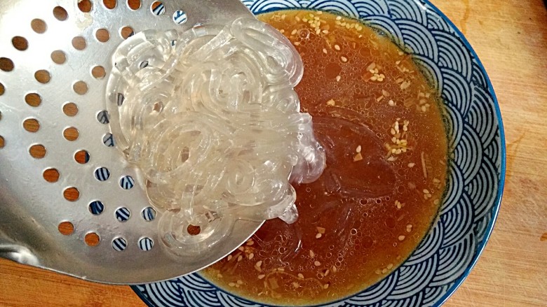 酸辣粉,随即捞起放入盛着高汤的碗里。