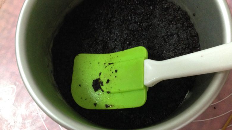 不用烤箱的甜点―奥利奥芒果慕斯,拌好的饼干末放入6寸活底模具内用手压实,放入冰箱冷冻40分钟(模具底部垫油纸)