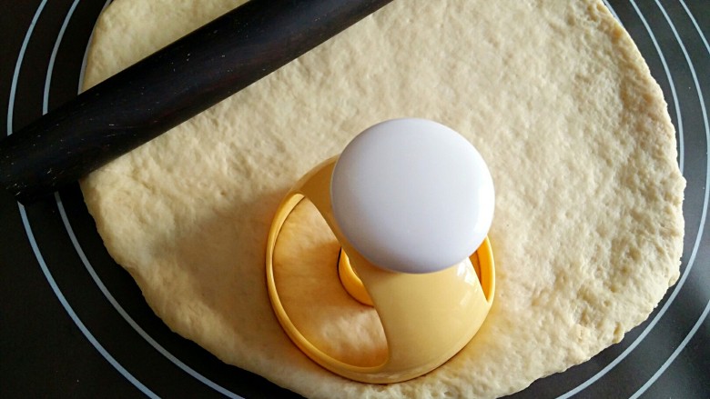 甜甜圈,将面团擀成厚1厘米左右的面饼，用模具在上面印出甜甜圈形状的饼胚。