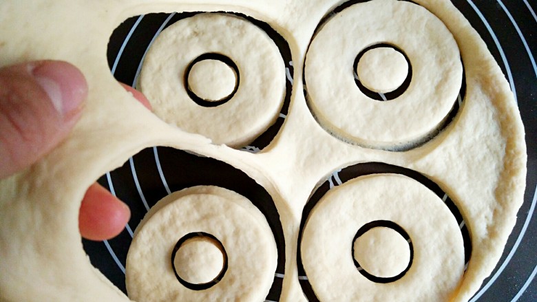 甜甜圈,多余的面揭起来，揉圆后重复步骤8。刻出来的饼坯加盖保鲜膜，二次醒发30分钟。