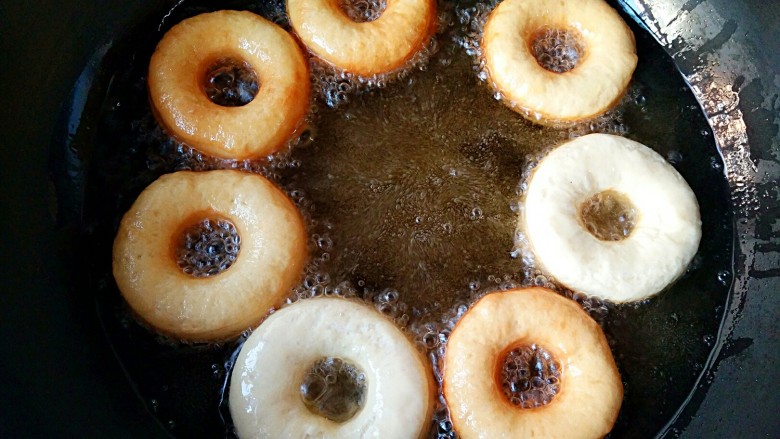 甜甜圈,炸至一面上色后翻面。