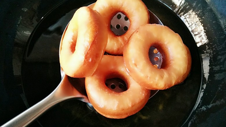 甜甜圈,炸的过程中，可以视情况翻面，炸至两面金黄后即可沥油捞出。