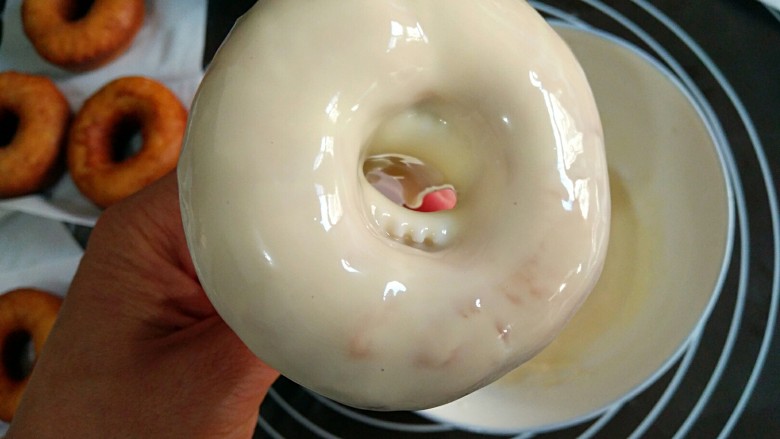 甜甜圈,这里需要注意的是，甜甜圈翻过来时要迅速，不然会出现“滴泪”（流到背面）的情况，同时用拇指和小指轻轻捏住并微微晃动，让巧克力在上面呈现出均匀的状态。