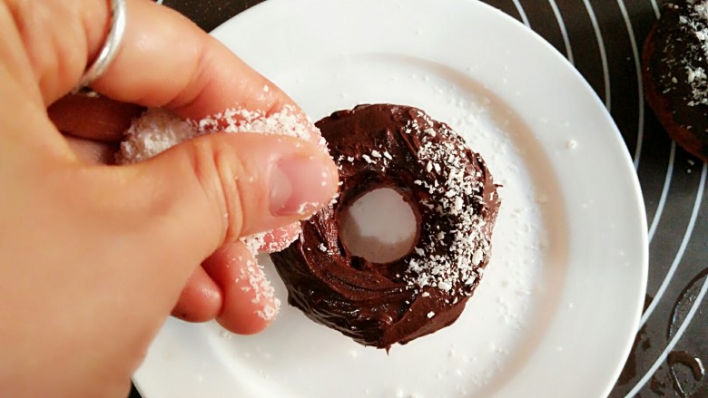 甜甜圈,同样的方法给甜甜圈包裹一层黑巧克力，并在巧克力未干时撒上一层<a style='color:red;display:inline-block;' href='/shicai/ 630'>椰蓉</a>。