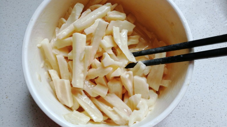 孜然干煸藕条,然后把沥干的藕条放入脆皮糊中翻拌均匀挂糊;