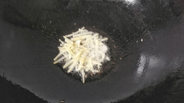 孜然干煸藕条,锅中留底油,先放入姜丝煸出香味;