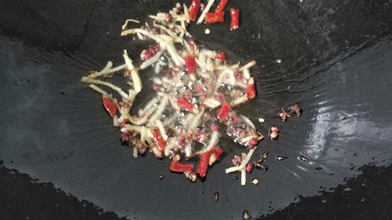 孜然干煸藕条,再放入花椒和干红辣椒煸出香味;