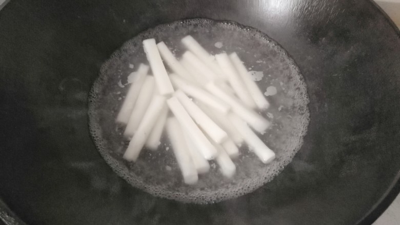 黑椒火腿炒年糕,锅中烧热水,放入年糕煮一会儿;