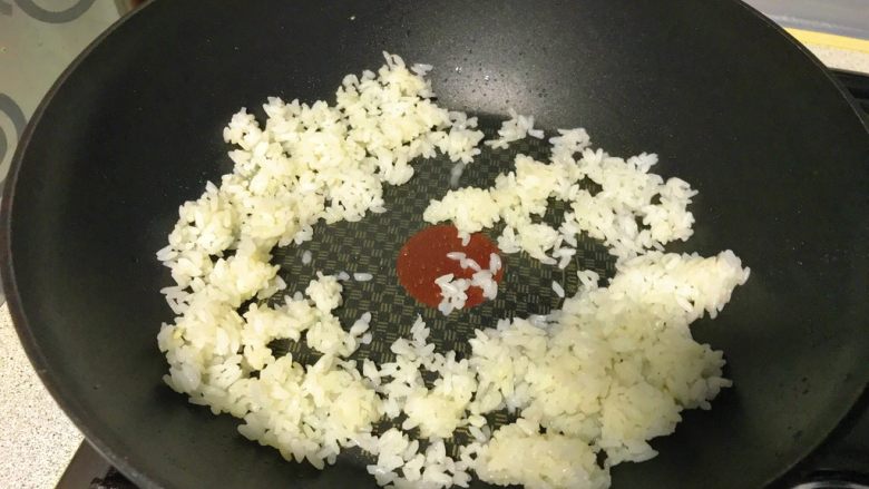 彩虹蛋炒饭,另起锅,淋一汤匙油,倒入剩饭,炒散。