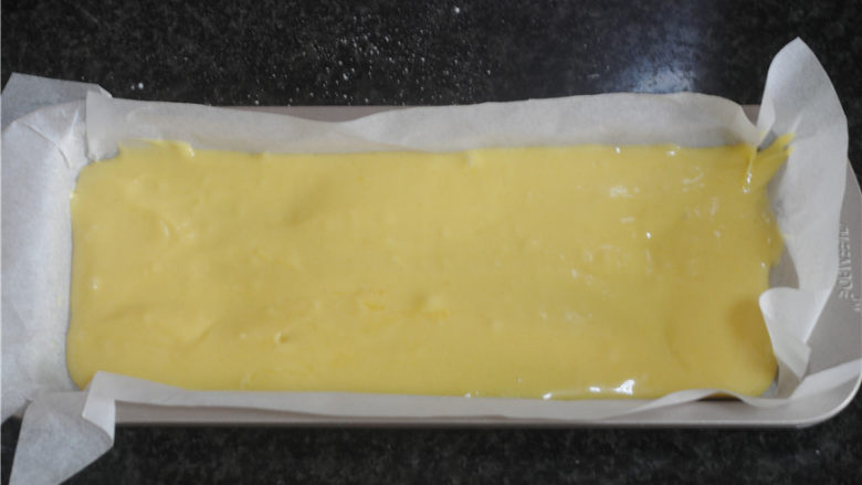 蓝莓蛋糕,将面糊倒入铺了油纸的模具里,用刮刀抹平