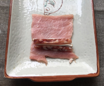 腊味里脊卷,把腊肠条、香菇条放在里脊片的一端