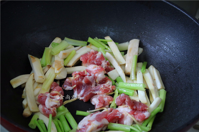 鲜肉鸡腿菇烩糍粑,倒入瘦肉和芹菜，大火煸炒片刻