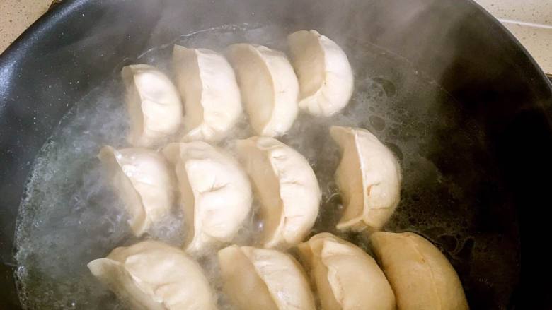 葱香煎饺,然后加入适量的开水,水要淹没饺子的1/3,转大火煮大概4分钟左右