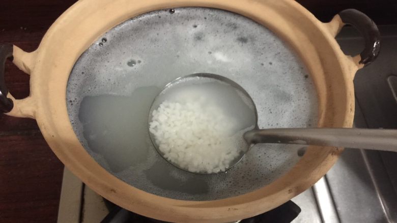 潮汕美味——海鲜砂锅粥,大米淘洗后放入砂锅中,加入适量的水,大火开煮。